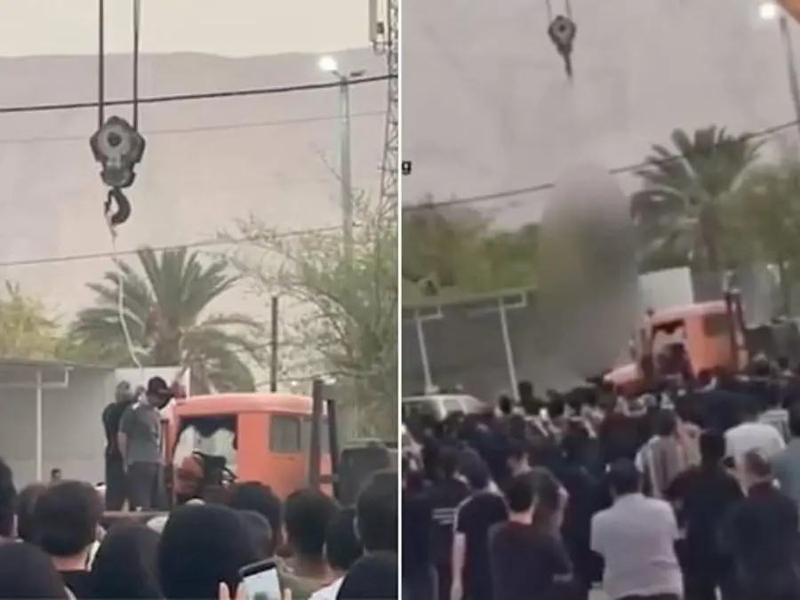Iranian man convicted of murder hanged publicly from a crane at crime scene